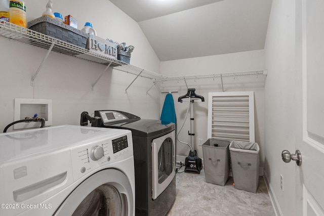 laundry room featuring washer and dryer and light tile patterned floors