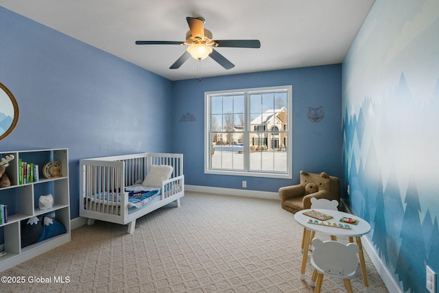 bedroom featuring carpet floors, a crib, and ceiling fan