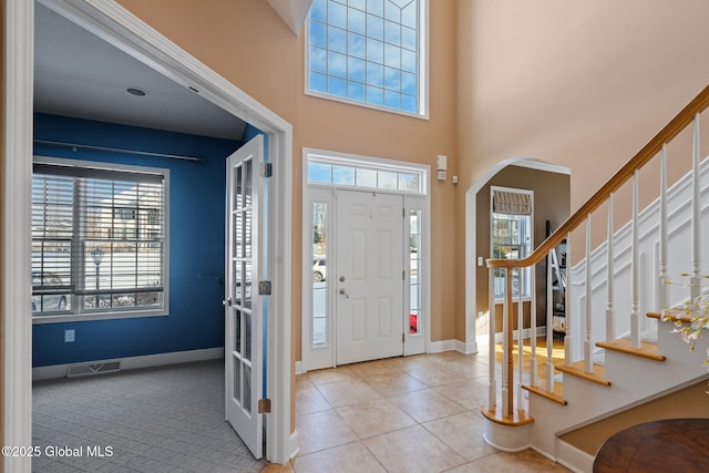 tiled entryway with a towering ceiling