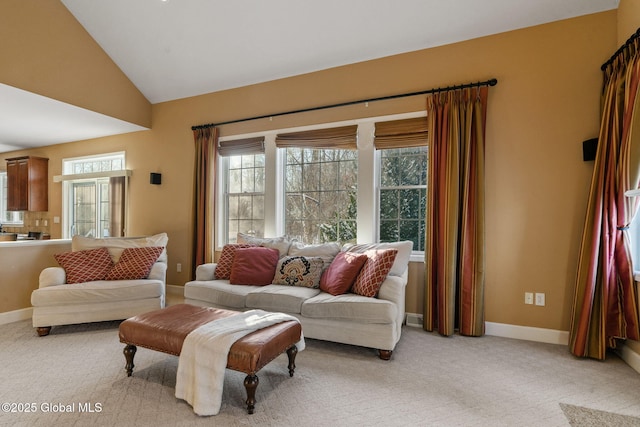 carpeted living room with high vaulted ceiling