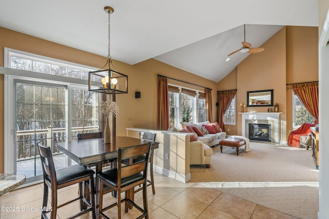 dining area featuring vaulted ceiling, ceiling fan with notable chandelier, and light tile patterned floors