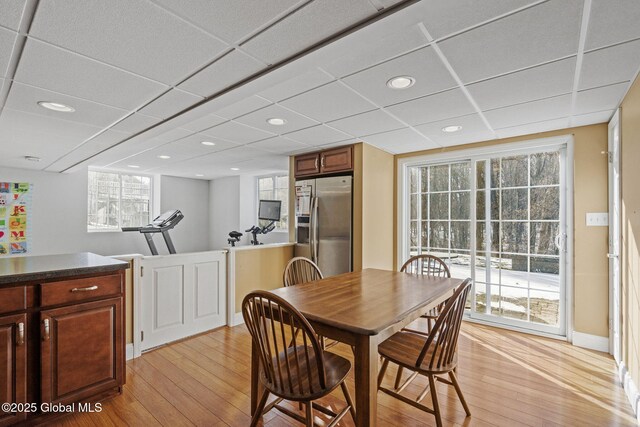 dining room featuring a paneled ceiling and light wood-type flooring