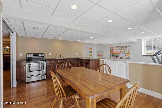 dining space with sink, a paneled ceiling, and dark hardwood / wood-style floors