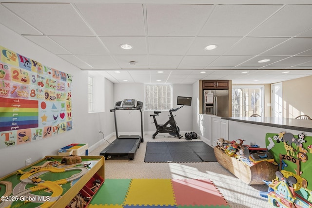 workout area featuring light carpet and a drop ceiling