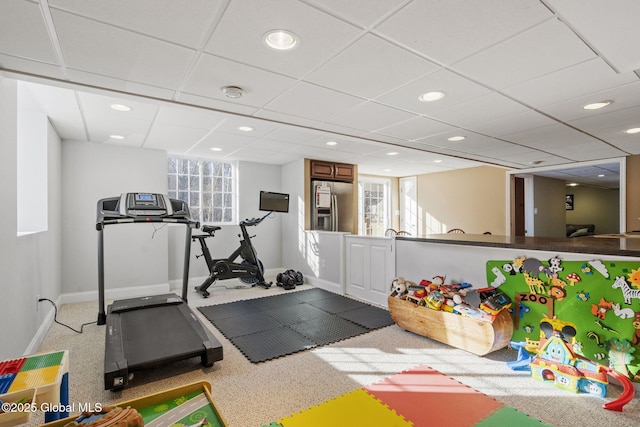 exercise room featuring carpet and a drop ceiling