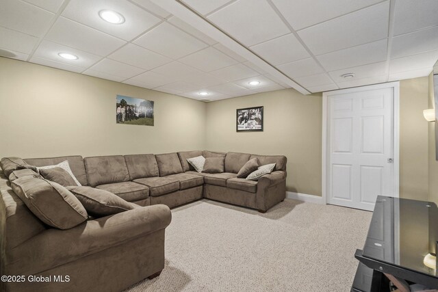 living room featuring a paneled ceiling and carpet flooring