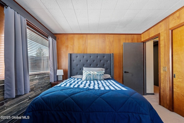 bedroom featuring wooden walls and carpet