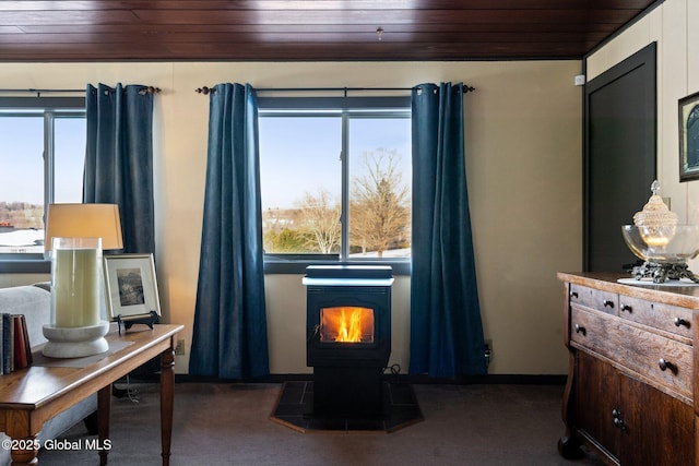 interior space with multiple windows, a wood stove, and wood ceiling