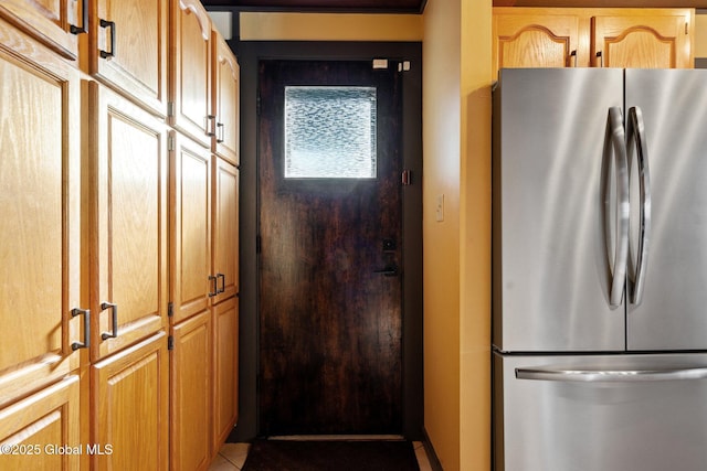 kitchen with light tile patterned floors and stainless steel refrigerator