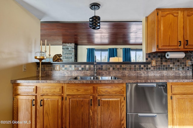 kitchen featuring tasteful backsplash, hanging light fixtures, sink, and dishwashing machine