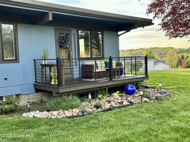 deck at dusk featuring a lawn