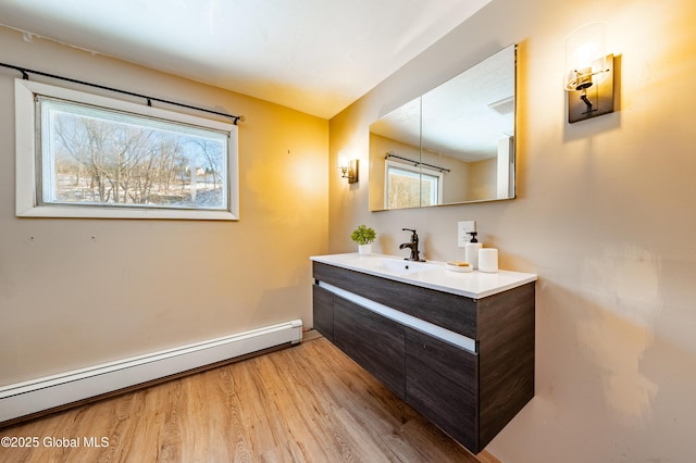 bathroom featuring hardwood / wood-style flooring, vanity, and a baseboard heating unit