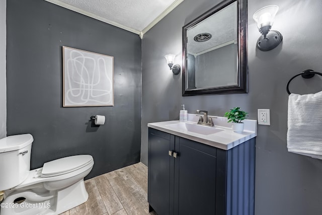 bathroom featuring ornamental molding, toilet, a textured ceiling, and vanity