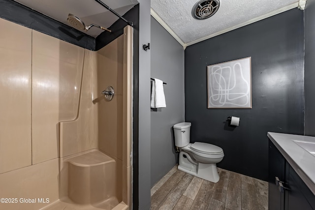 bathroom featuring ornamental molding, wood-type flooring, a textured ceiling, and a shower