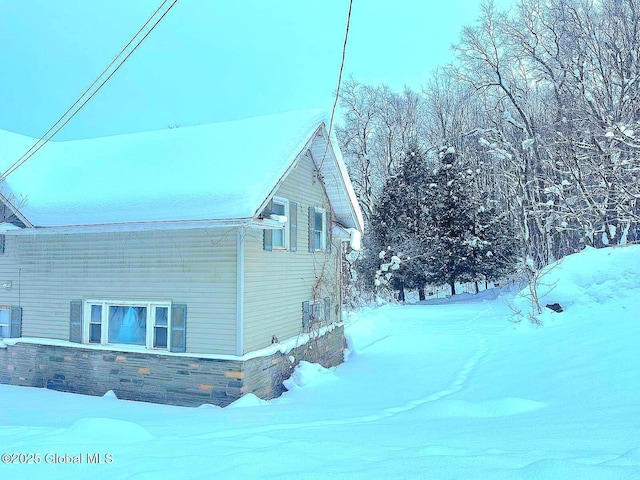 view of snow covered exterior featuring central AC unit