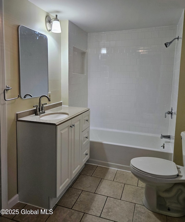 full bathroom featuring tiled shower / bath, vanity, tile patterned floors, and toilet