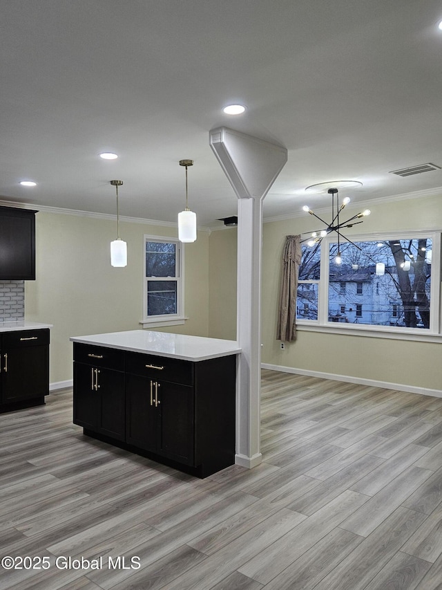 kitchen with crown molding, backsplash, light hardwood / wood-style floors, and decorative light fixtures