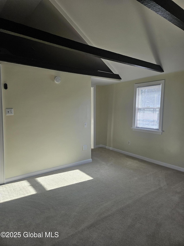 spare room featuring vaulted ceiling with beams and carpet