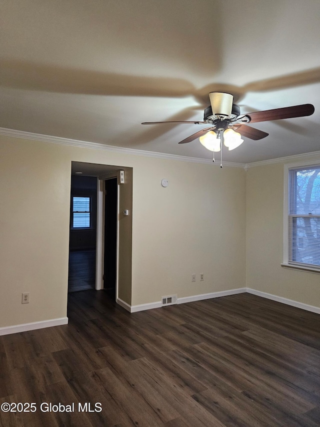 unfurnished room with dark wood-type flooring, ornamental molding, and plenty of natural light