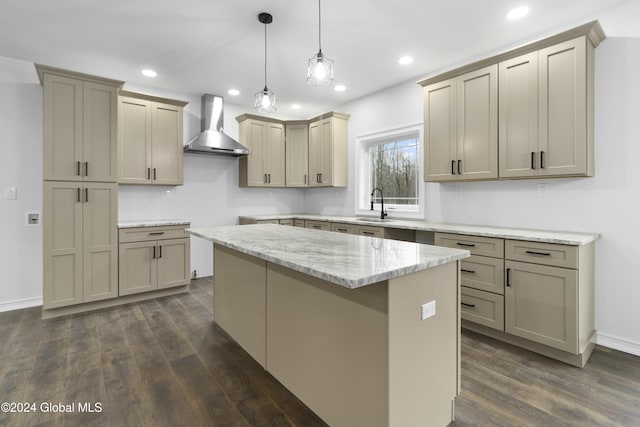 kitchen with dark hardwood / wood-style flooring, decorative light fixtures, a kitchen island, sink, and wall chimney range hood