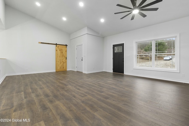 unfurnished living room featuring ceiling fan, high vaulted ceiling, dark hardwood / wood-style flooring, and a barn door