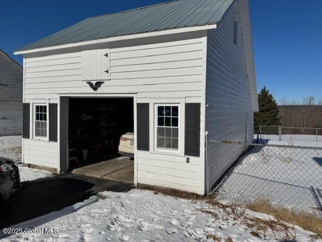 snow covered structure featuring a garage