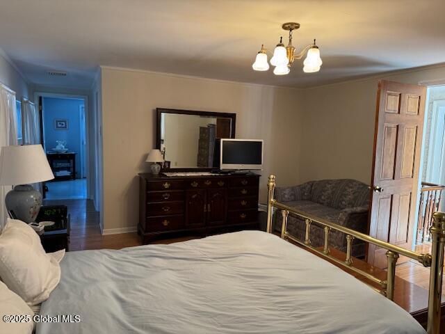 bedroom featuring wood-type flooring and a chandelier