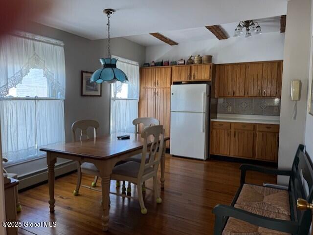 dining space featuring dark wood-type flooring, ceiling fan, and a baseboard heating unit