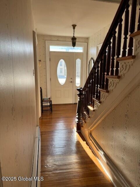 entryway with dark wood-type flooring and baseboard heating