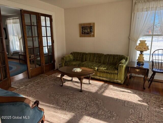 living room with wood-type flooring, plenty of natural light, and french doors