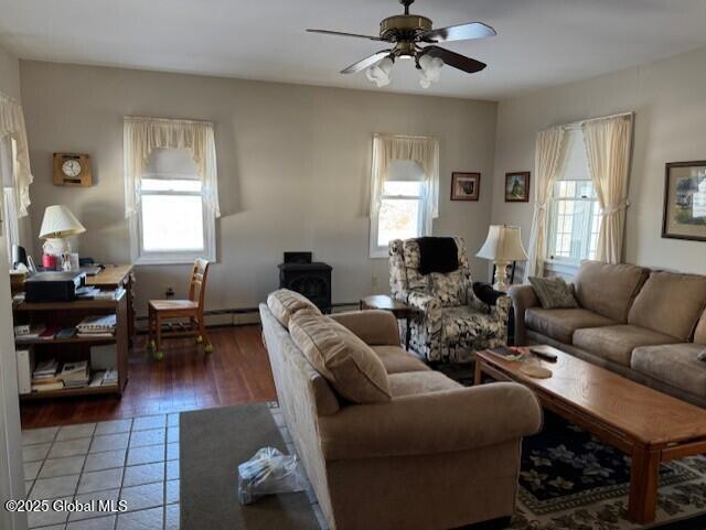 living room featuring ceiling fan, hardwood / wood-style floors, a healthy amount of sunlight, and baseboard heating