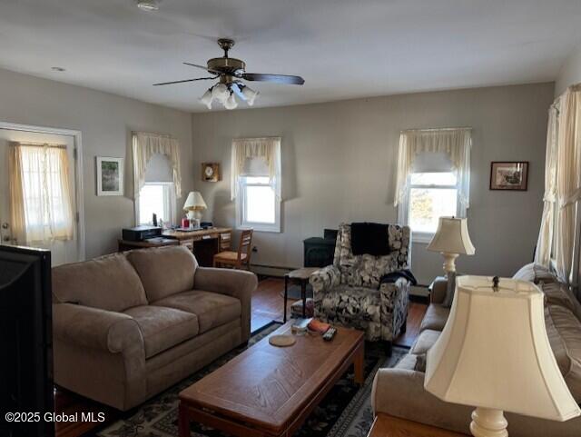 living room with a baseboard heating unit and ceiling fan