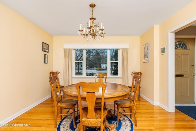 dining space with an inviting chandelier and light hardwood / wood-style floors