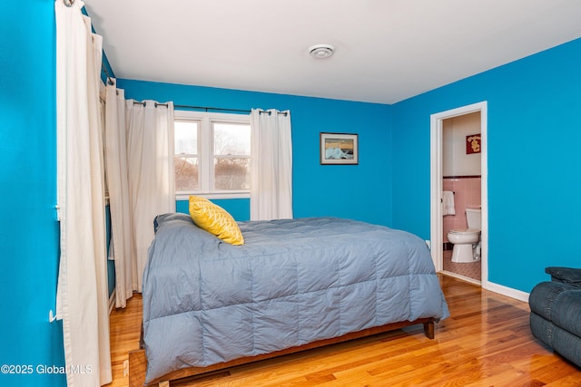 bedroom featuring ensuite bath and light hardwood / wood-style flooring