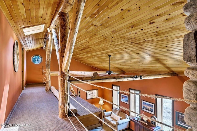 interior space featuring wood ceiling, carpet flooring, and lofted ceiling with skylight