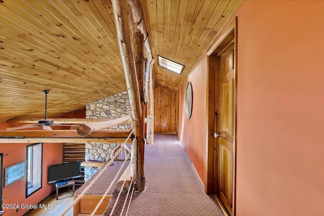 hallway featuring wood ceiling, carpet floors, and vaulted ceiling