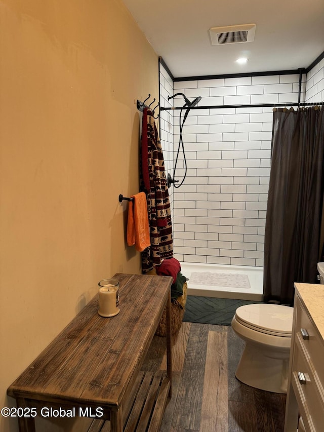 bathroom with a shower with curtain, vanity, wood-type flooring, and toilet