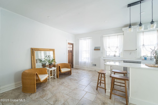 kitchen with light countertops, a healthy amount of sunlight, white cabinetry, and visible vents