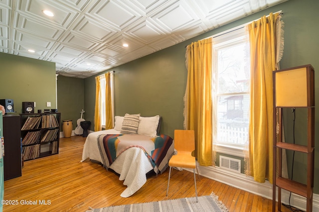 bedroom with visible vents, light wood-style flooring, an ornate ceiling, and recessed lighting