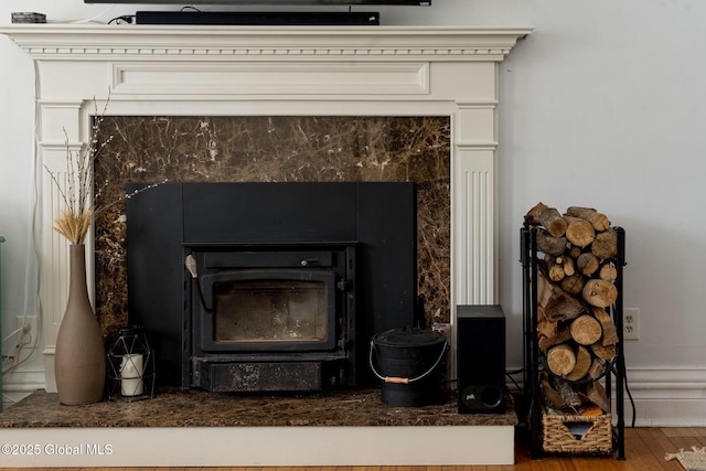 interior details with wood finished floors and a wood stove