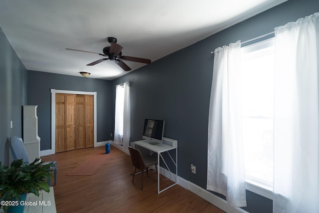 office area with ceiling fan, baseboards, and wood finished floors