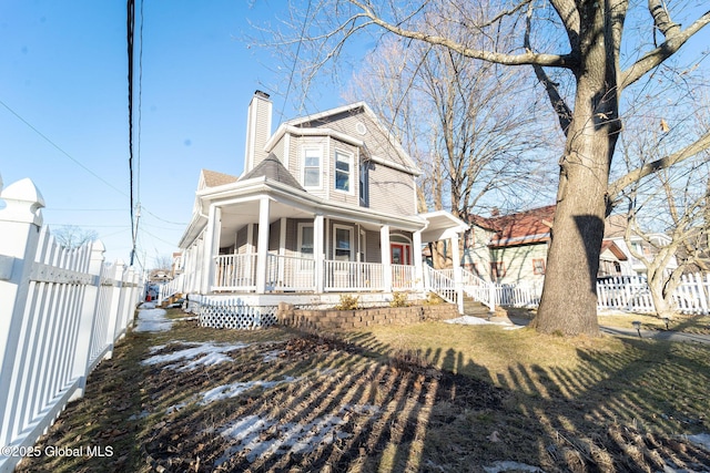 view of front of house with a chimney, fence, and a porch