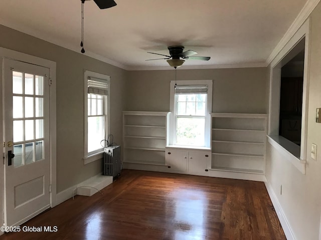 unfurnished room featuring dark hardwood / wood-style flooring, ornamental molding, and ceiling fan