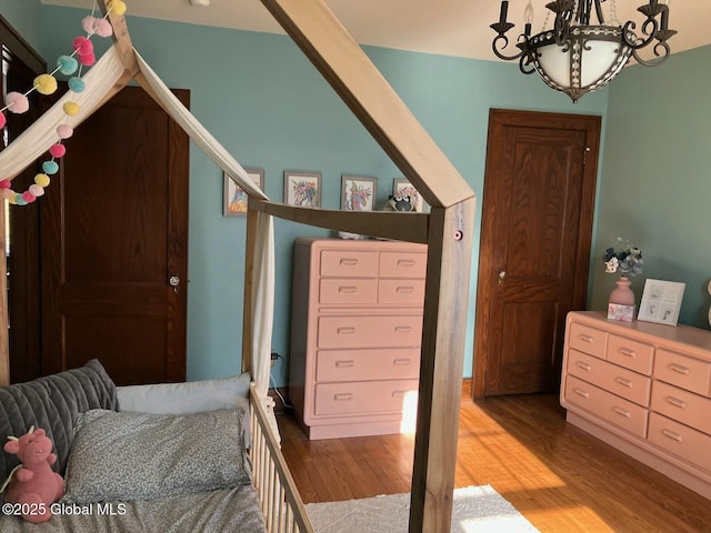 bedroom with an inviting chandelier and wood-type flooring