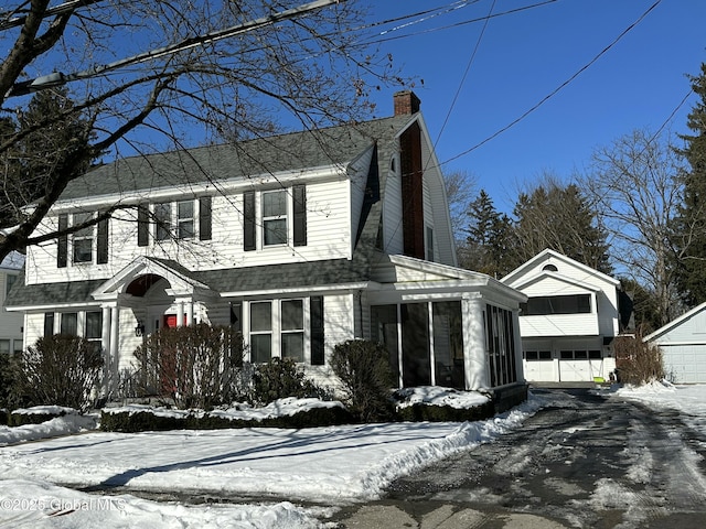 view of front of home featuring a garage and a sunroom