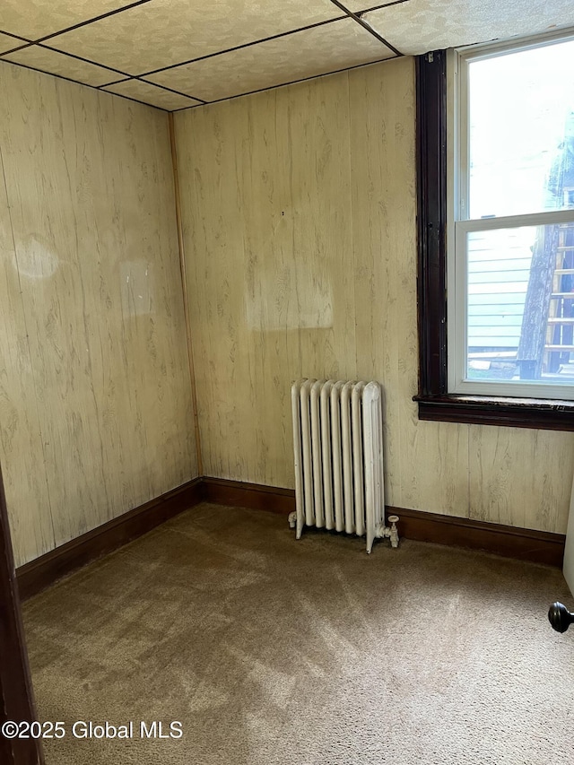 empty room with radiator and carpet flooring