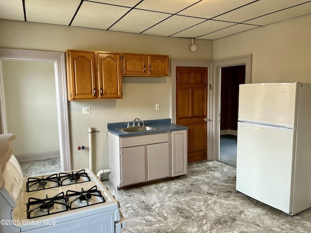 kitchen with white appliances, a paneled ceiling, and sink