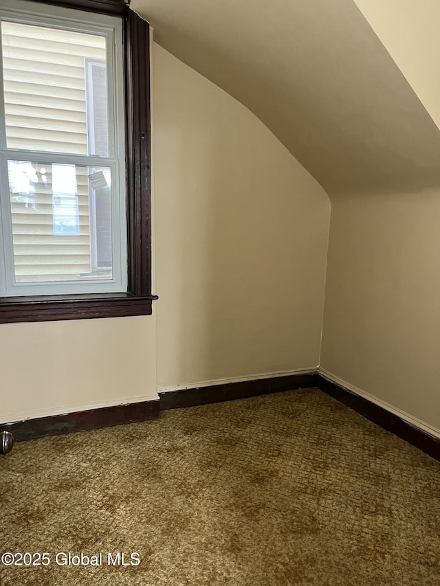 bonus room with carpet flooring and vaulted ceiling