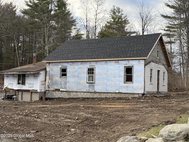 view of property exterior featuring a shingled roof