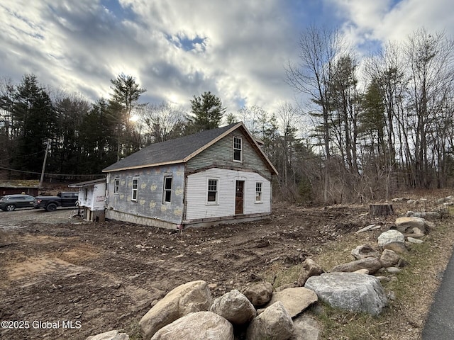 view of side of home with roof with shingles